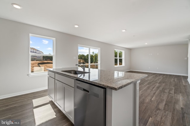 kitchen with a wealth of natural light, dishwasher, a center island with sink, and sink