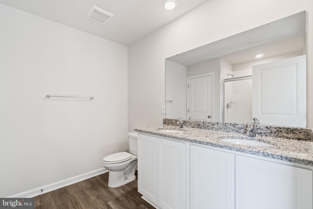 bathroom featuring hardwood / wood-style floors, vanity, toilet, and walk in shower