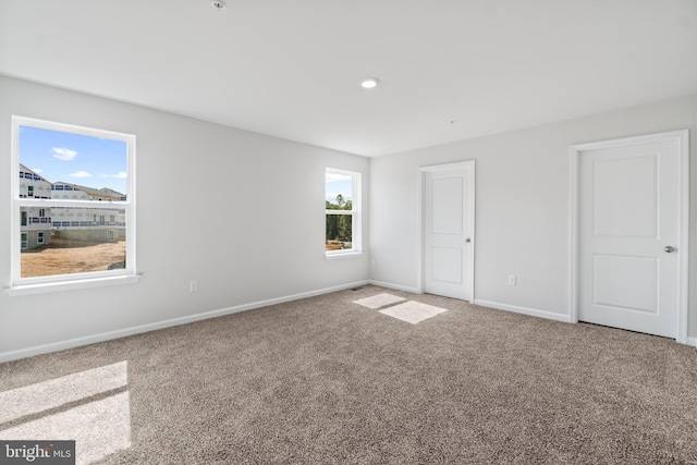 unfurnished bedroom with multiple windows and carpet