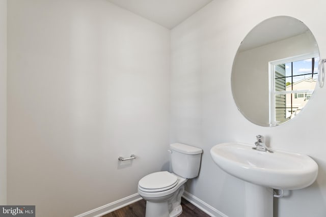 bathroom featuring toilet, wood-type flooring, and sink