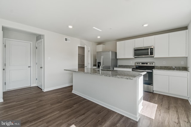 kitchen featuring a kitchen island with sink, dark hardwood / wood-style flooring, white cabinets, and stainless steel appliances