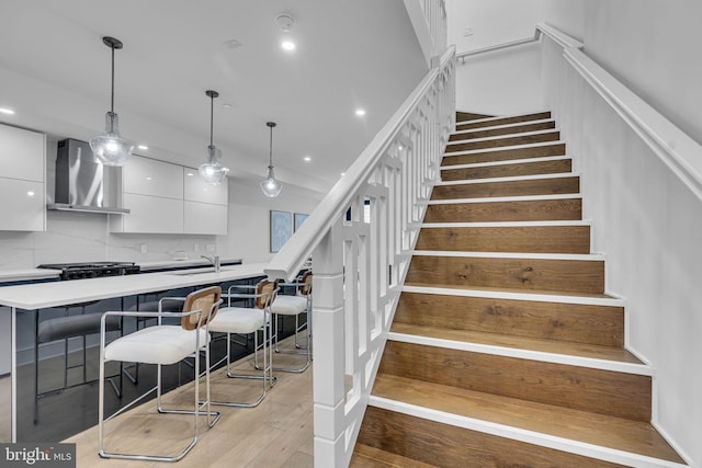 staircase featuring hardwood / wood-style floors and sink