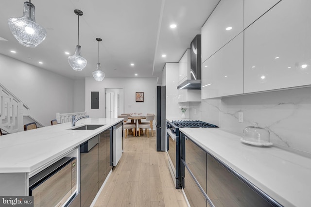 kitchen featuring stainless steel appliances, hanging light fixtures, sink, and wall chimney exhaust hood