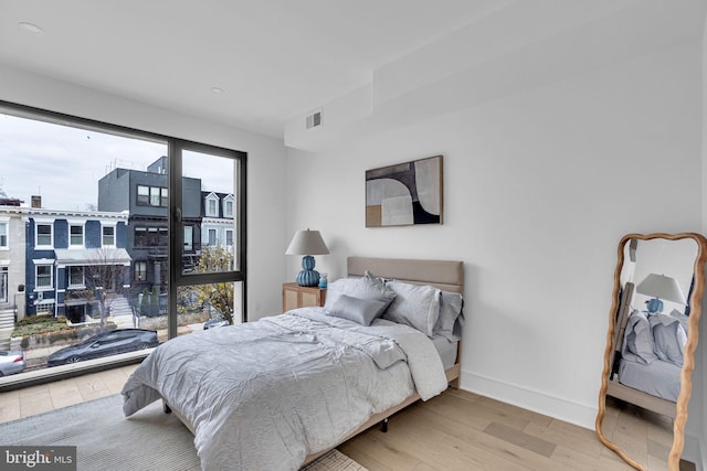 bedroom featuring multiple windows and light wood-type flooring