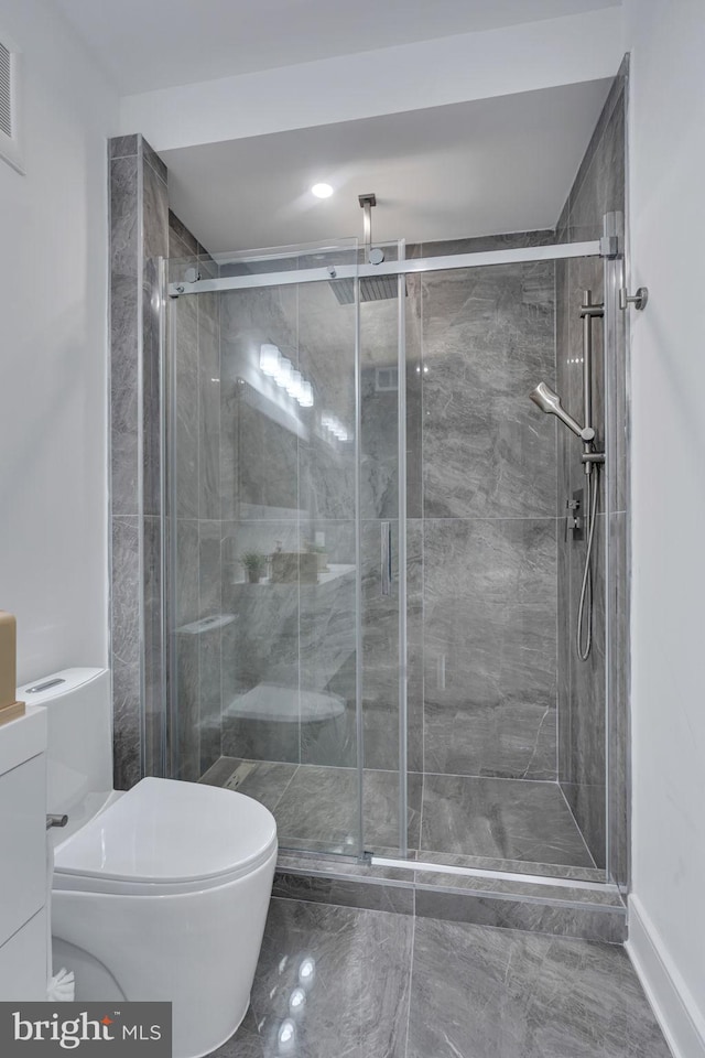 bathroom with toilet and an enclosed shower