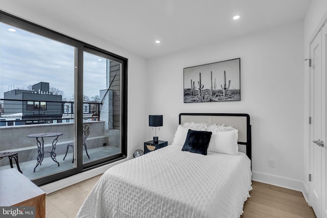 bedroom with access to exterior and light hardwood / wood-style floors