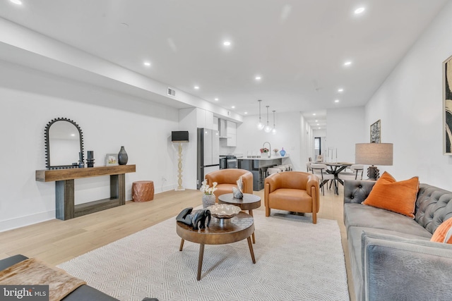 living room with sink and light hardwood / wood-style floors