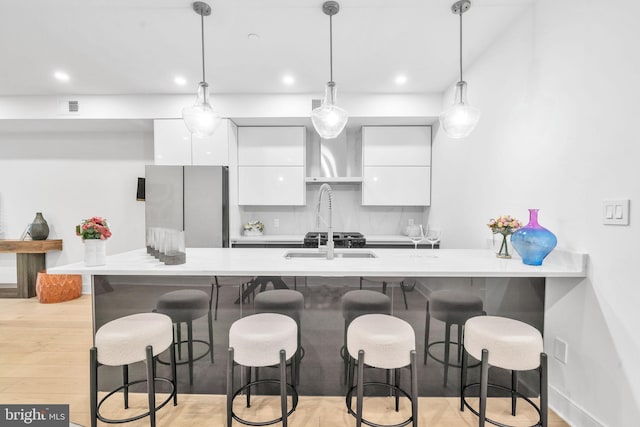 kitchen featuring tasteful backsplash, white cabinetry, a kitchen bar, and decorative light fixtures