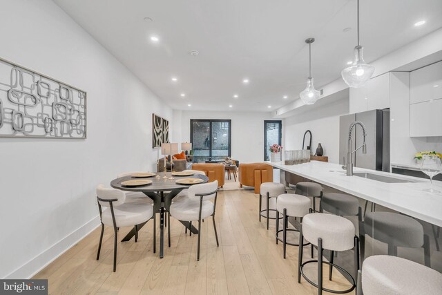 dining space with sink and light hardwood / wood-style flooring