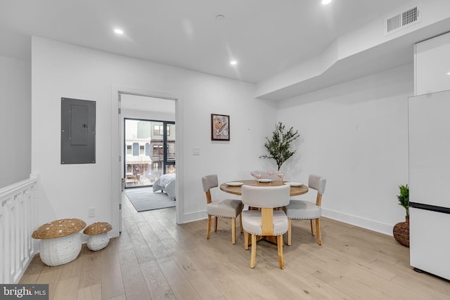 dining space featuring electric panel and light wood-type flooring