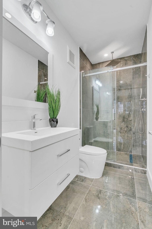 bathroom with toilet, vanity, and walk in shower