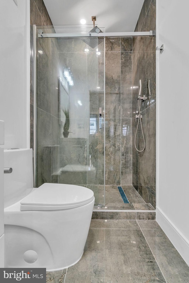 bathroom featuring toilet and an enclosed shower