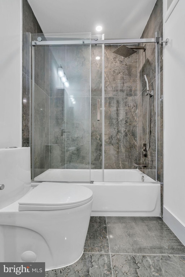 bathroom featuring enclosed tub / shower combo and toilet