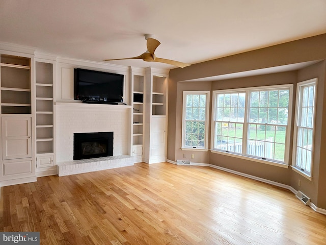 unfurnished living room featuring ceiling fan, a fireplace, and light hardwood / wood-style flooring