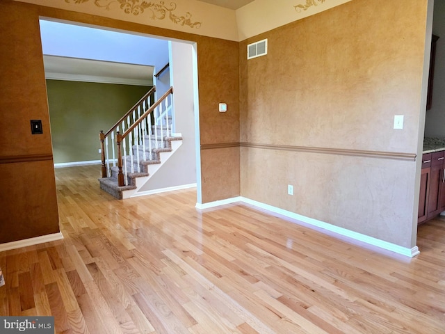 spare room featuring light hardwood / wood-style flooring and ornamental molding