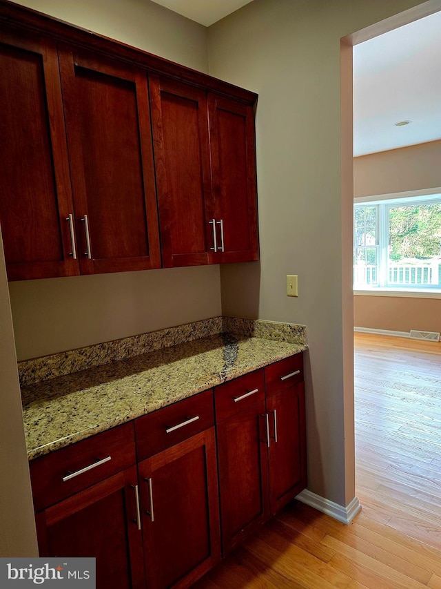 kitchen featuring light stone counters and light hardwood / wood-style flooring