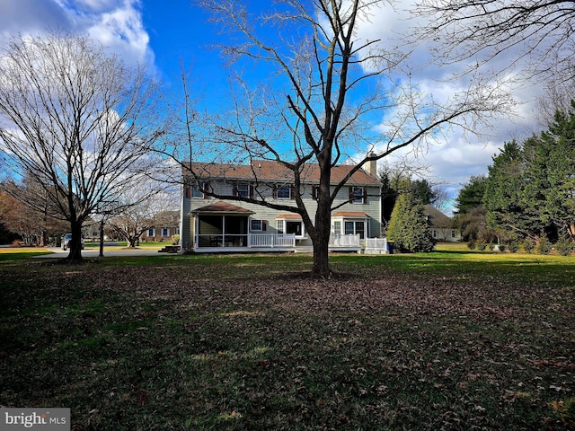 back of house featuring a lawn