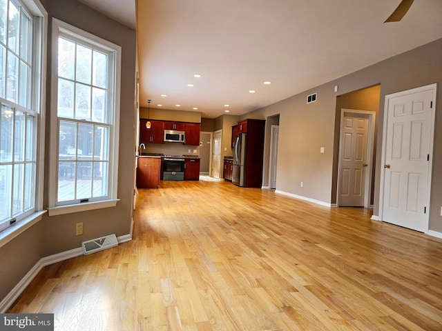 unfurnished living room with light hardwood / wood-style floors and sink