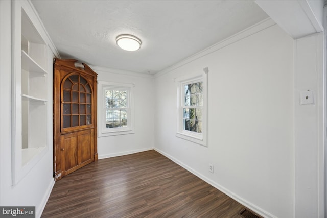 unfurnished room featuring a textured ceiling, dark hardwood / wood-style floors, and crown molding