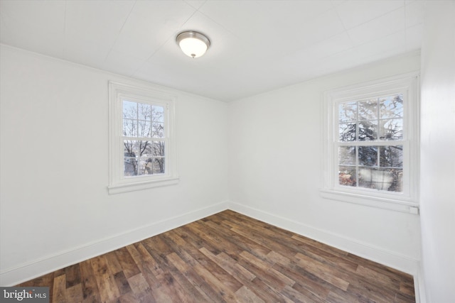 spare room with dark wood-type flooring and a healthy amount of sunlight