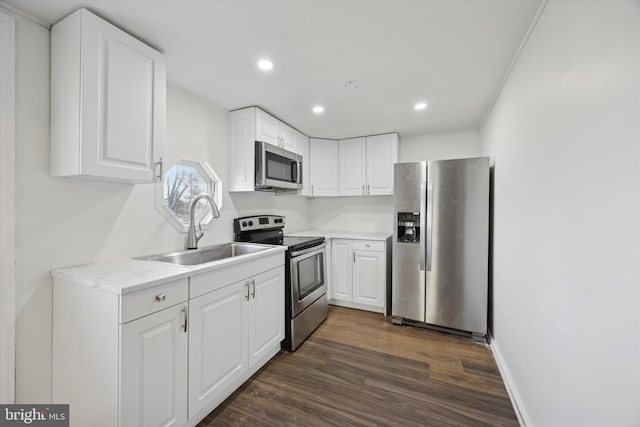 kitchen with light stone countertops, stainless steel appliances, sink, white cabinets, and dark hardwood / wood-style floors