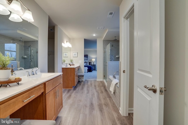 bathroom with hardwood / wood-style flooring, vanity, and walk in shower