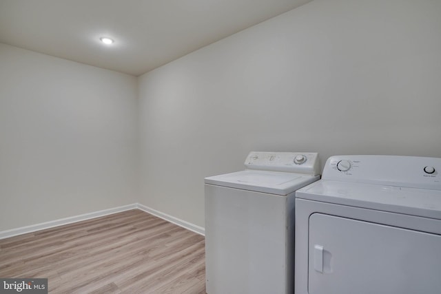 laundry room featuring washer and dryer and light wood-type flooring