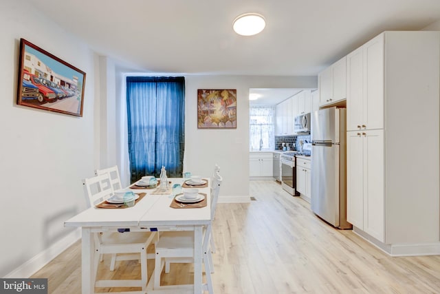 dining space with light hardwood / wood-style floors