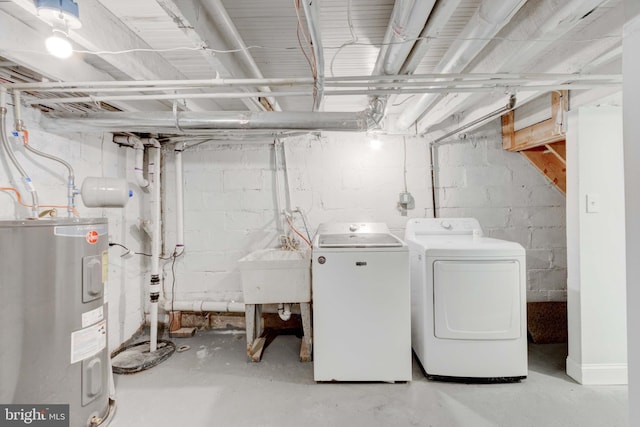 laundry room featuring water heater, washing machine and dryer, and sink