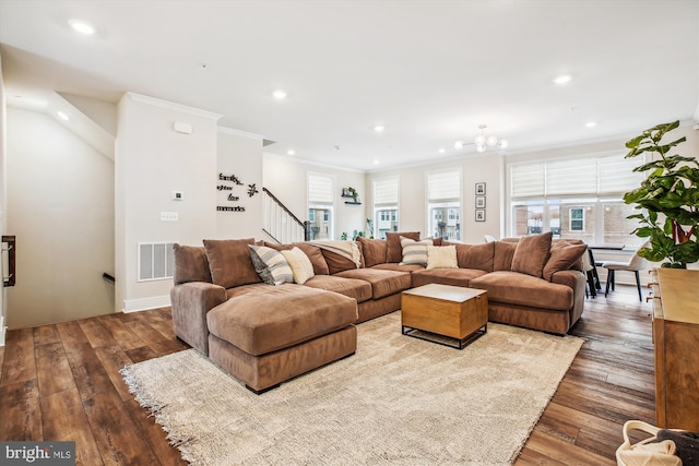 living room with crown molding, wood-type flooring, and a chandelier