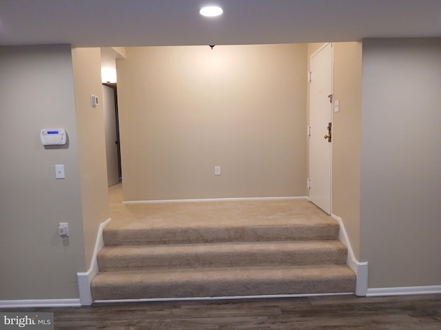 stairs featuring hardwood / wood-style floors