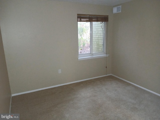 spare room featuring light colored carpet