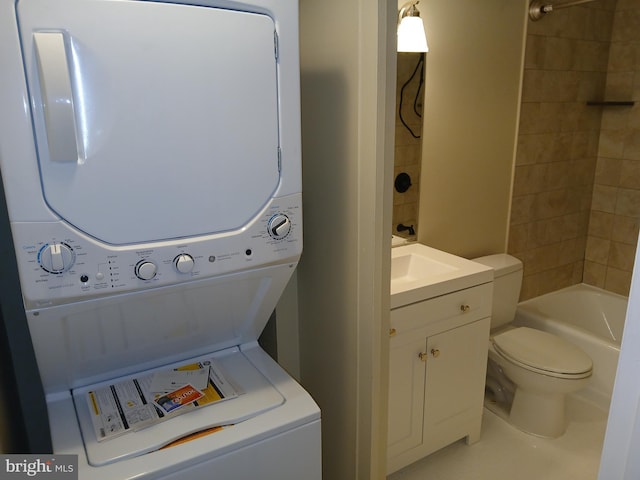 clothes washing area featuring sink and stacked washer / dryer