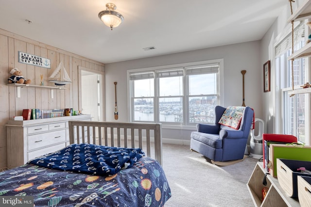 carpeted bedroom with wood walls