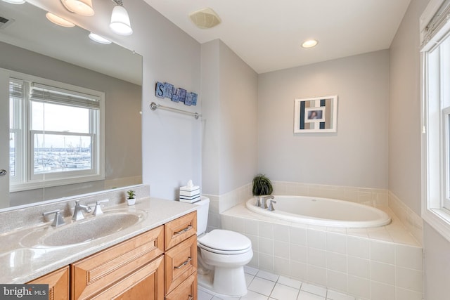 bathroom featuring a relaxing tiled tub, tile patterned floors, toilet, and vanity