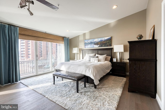 bedroom with lofted ceiling, hardwood / wood-style floors, and access to outside