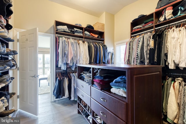 walk in closet featuring lofted ceiling and hardwood / wood-style flooring