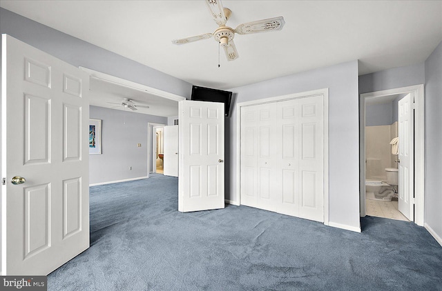 unfurnished bedroom featuring dark colored carpet, a closet, ceiling fan, and ensuite bathroom