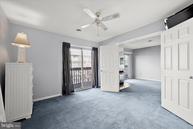 unfurnished living room with dark colored carpet, plenty of natural light, and ceiling fan