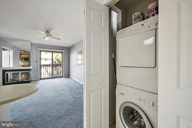 laundry area featuring ceiling fan, stacked washer and dryer, and carpet