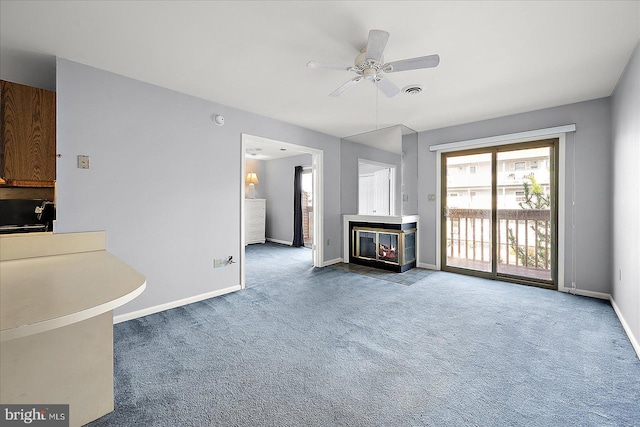 unfurnished living room featuring carpet floors and ceiling fan