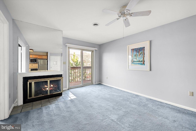 unfurnished living room featuring ceiling fan and carpet floors