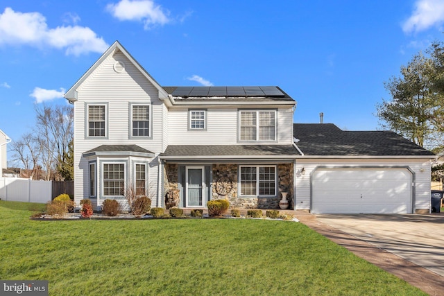 view of front property with a front yard, solar panels, and a garage