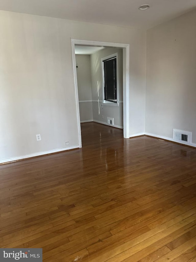 unfurnished room with dark hardwood / wood-style flooring