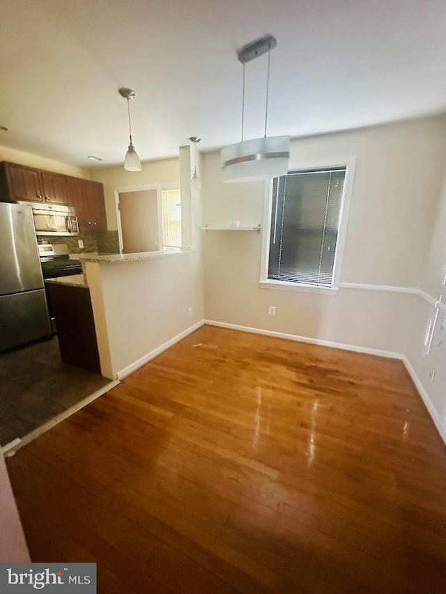 kitchen with decorative light fixtures, dark hardwood / wood-style flooring, and appliances with stainless steel finishes