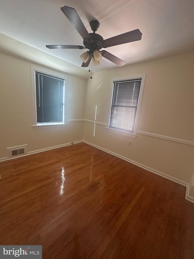 empty room with hardwood / wood-style floors and ceiling fan