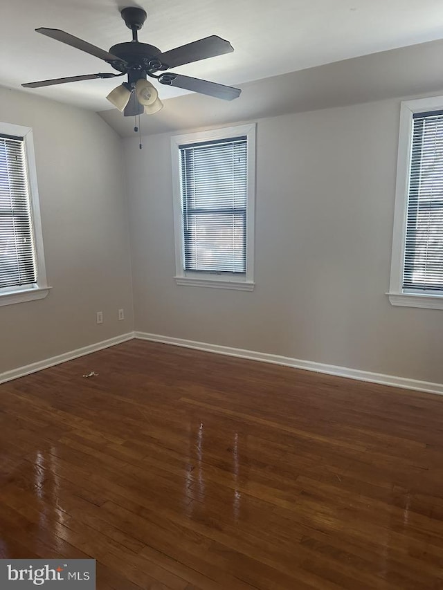 empty room with ceiling fan and dark wood-type flooring