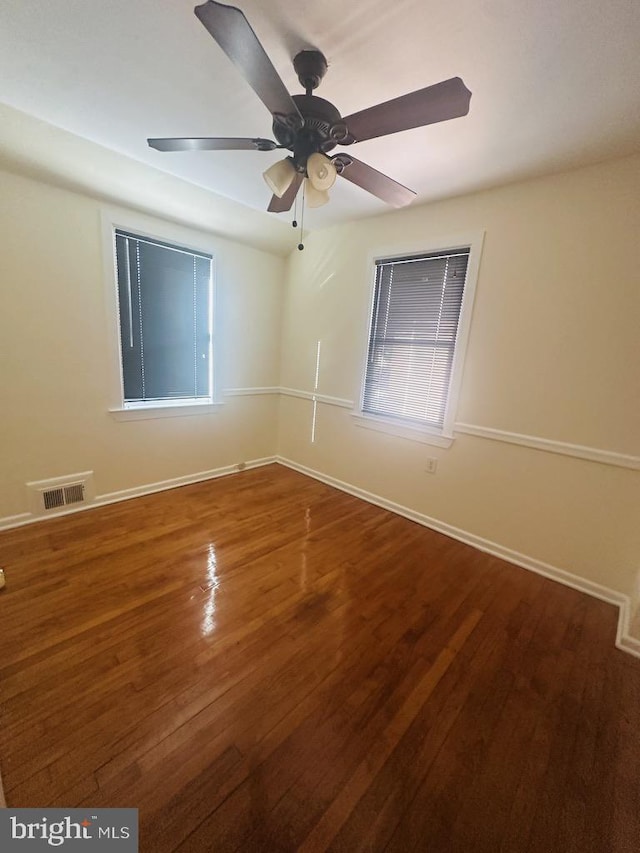 empty room featuring dark hardwood / wood-style flooring and ceiling fan