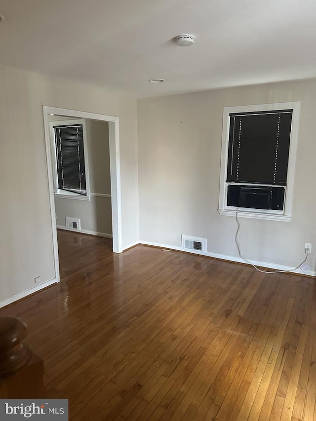 empty room featuring dark hardwood / wood-style floors and cooling unit