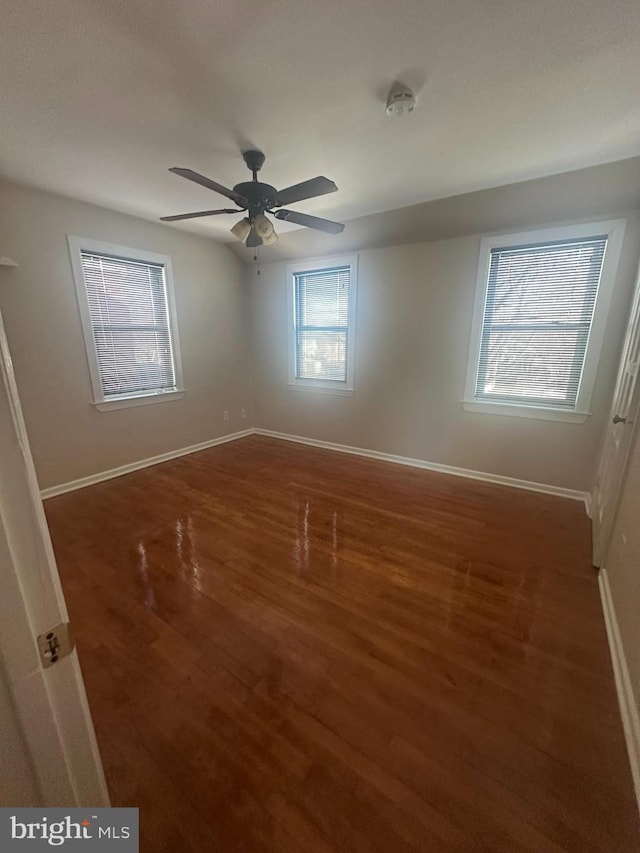 spare room with ceiling fan and dark hardwood / wood-style flooring